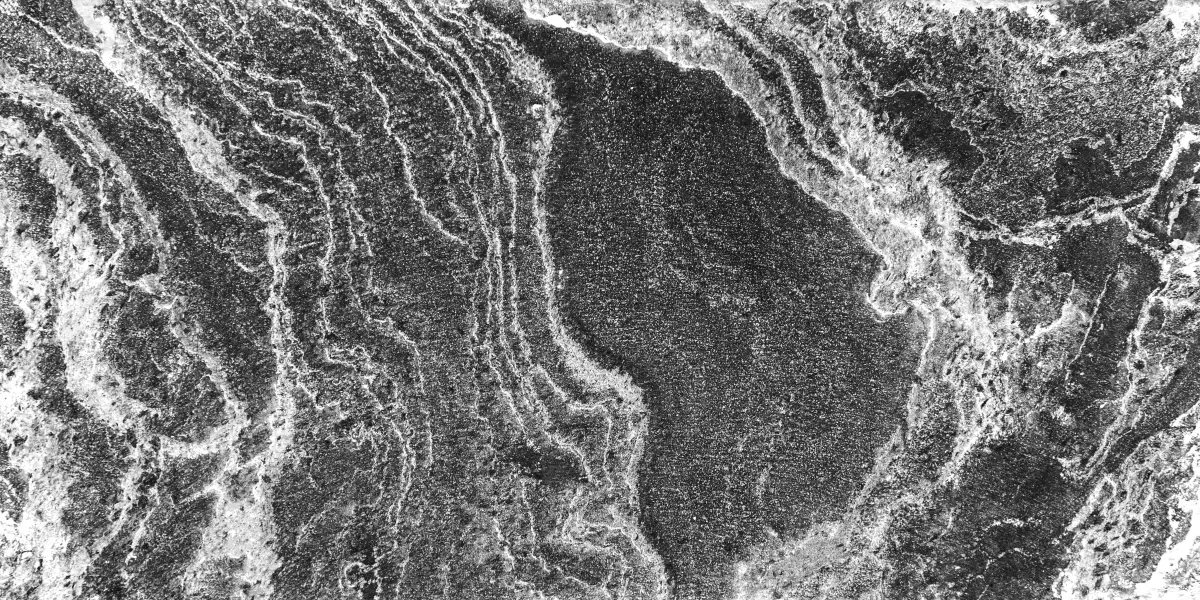 Schwarze Naturstein-Oberfläche mit heller Aderung als Sinnbild für Natursteinarbeitsplatten